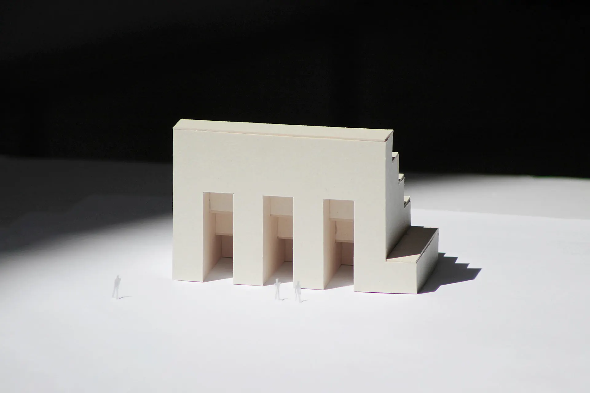Una maqueta blanca de cartón de un edificio con tres aberturas en arco